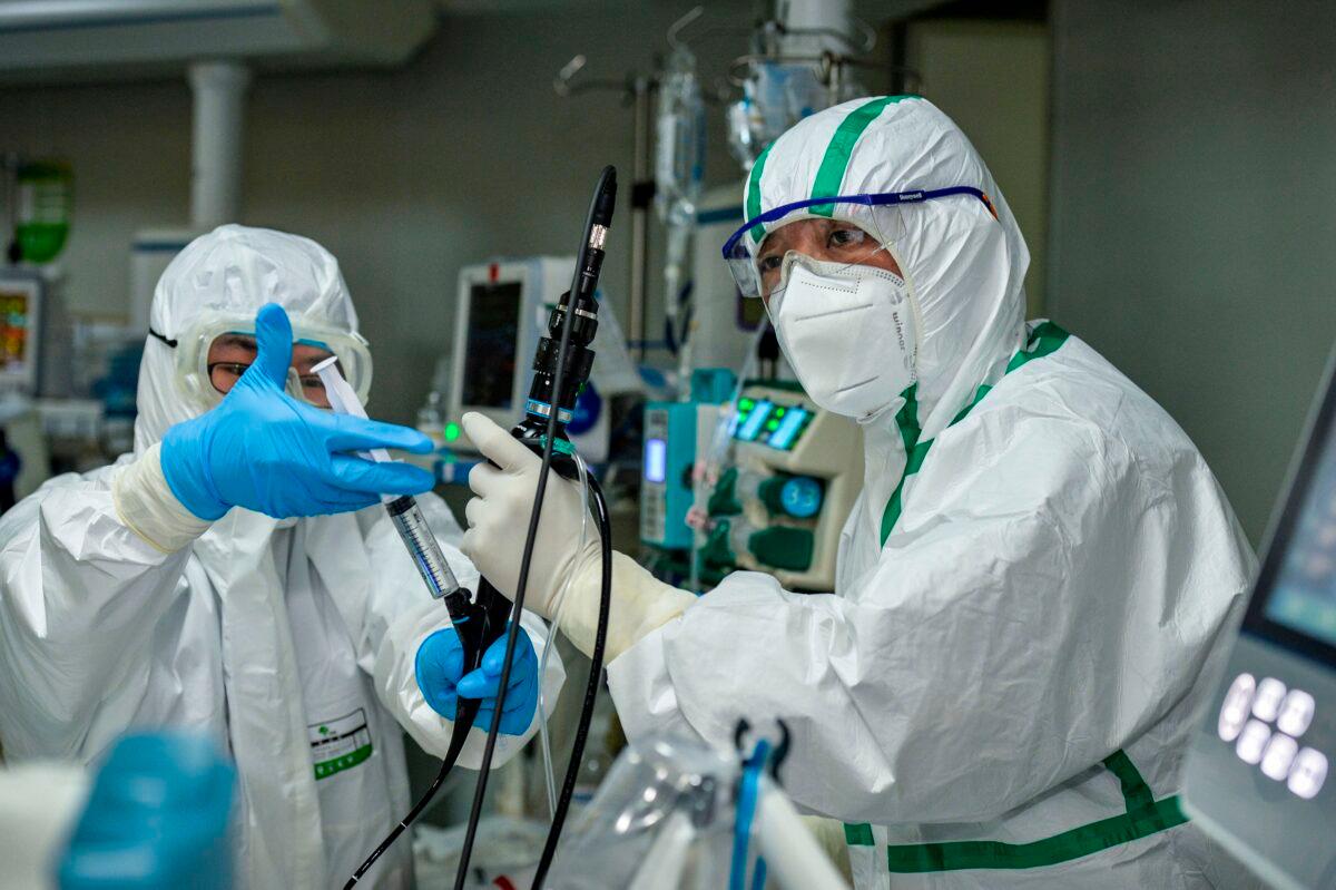 A doctor treats a patient infected by the COVID-19 coronavirus at a hospital in Wuhan in China's central Hubei province, on Feb. 24, 2020. (STR/AFP via Getty Images)