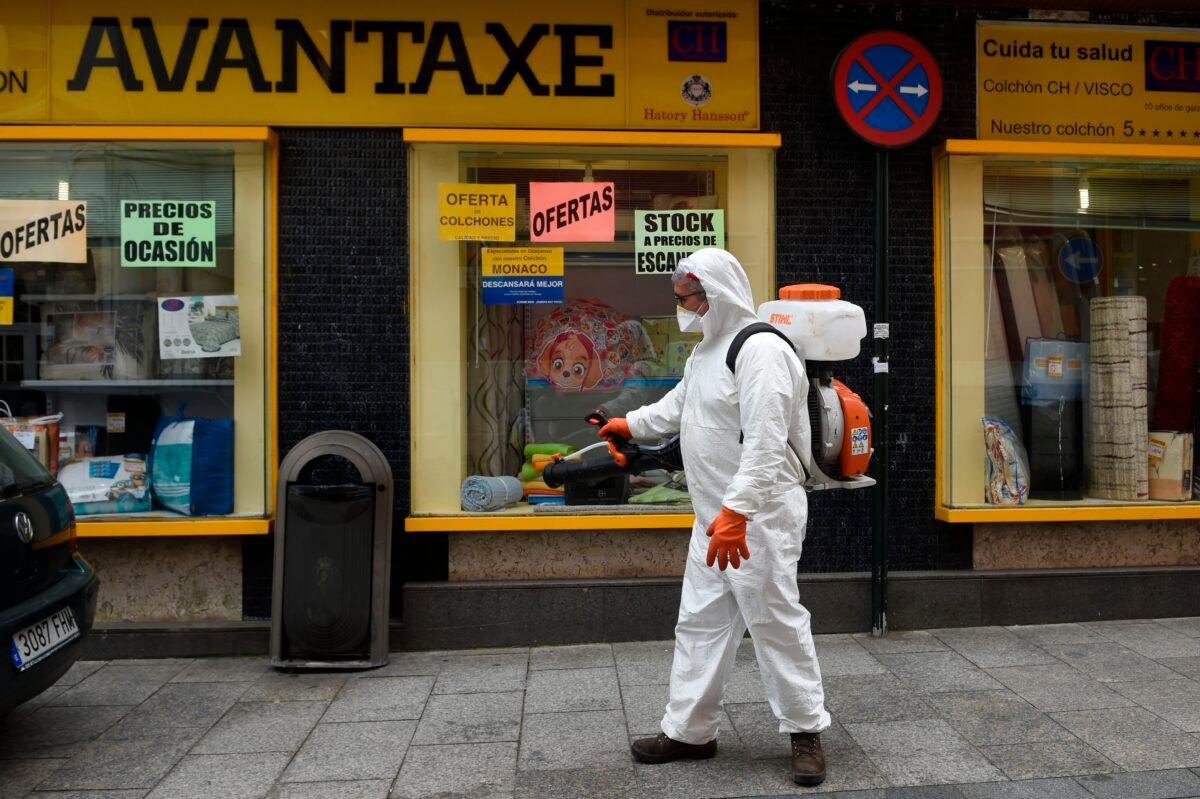 A man dressed in protective gear carries out disinfection work in a street in Vigo, northwestern Spain on March 31, 2020. (Miguel Riopa/AFP via Getty Images)