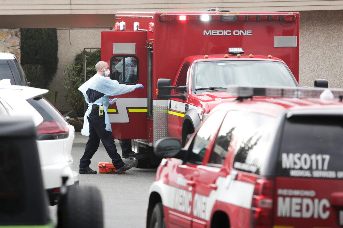 Ambulance staff prepare to transport a patient from the Life Care Center nursing home where some patients have died from COVID-19 in Kirkland, Wash., in a file photograph. (Jason Redmod/AFP via Getty Images)