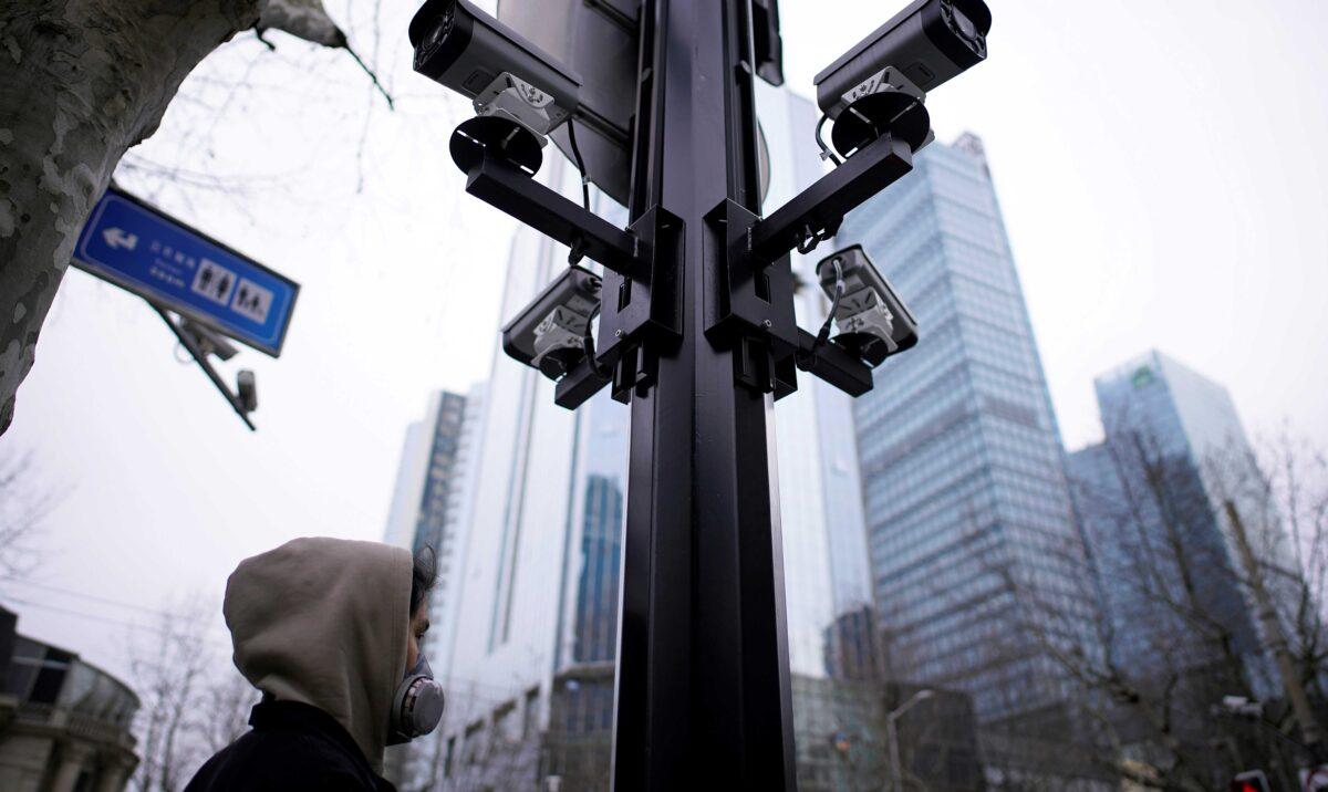 A man wearing a protective face mask walks under surveillance cameras as China is hit by an outbreak of the novel coronavirus, in Shanghai, on March 4, 2020. (Aly Song/Reuters)