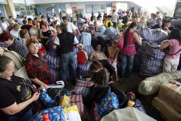 Russian traders rest with their goods at the railway station, after purchasing them at the Chinese border town of Suifenhe in northeastern Heilongjiang province on July 7, 2006. (GOH CHAI HIN/AFP via Getty Images)