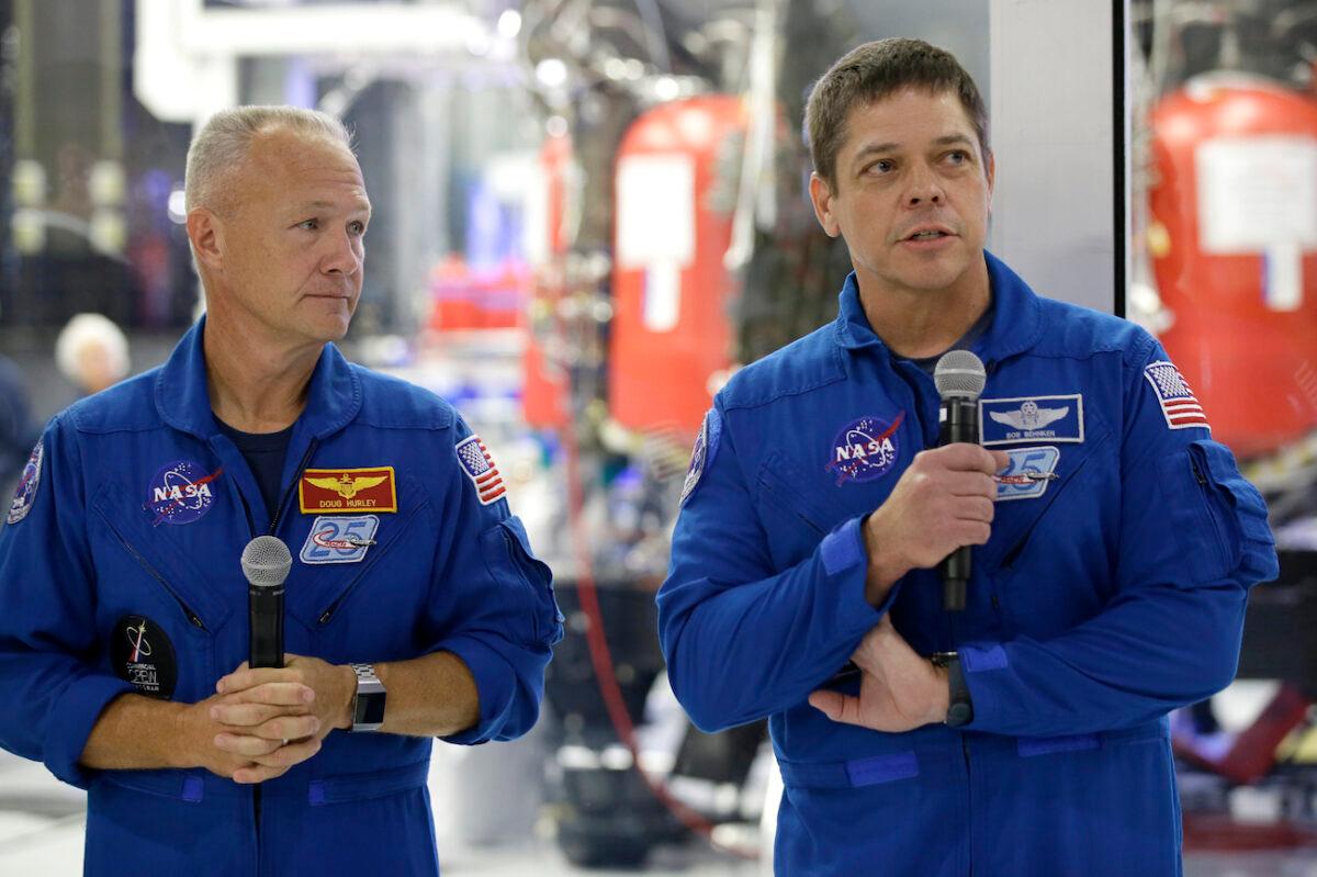 NASA astronauts Bob Behnken (R) and Doug Hurley talk to the media in front of the Crew Dragon spacecraft at SpaceX headquarters in Hawthorne, Calif., on Oct. 10, 2019. (Alex Gallardo/AP Photo)