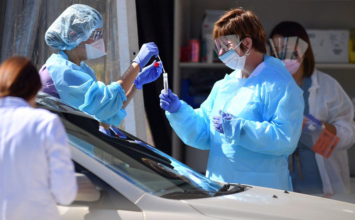 Medical workers at Kaiser Permanente French Campus test a patient for the novel coronavirus, COVID-19, at a drive-thru testing facility in San Francisco, Calif., on March 12, 2020.(Josh Edelson/AFP via Getty Images)