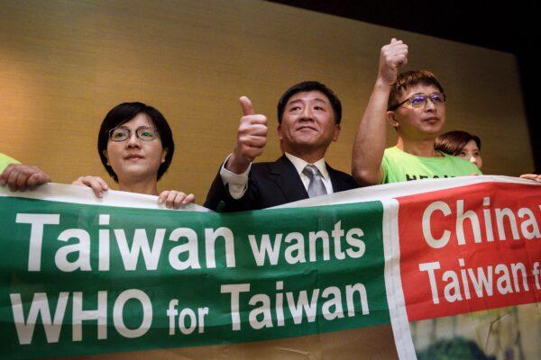 Taiwan's health Minister Chen Shih-chung (C) gives a thumb up as he poses with demonstrators after a press conference on the sideline of the World Health Organization's annual Assembly in Geneva on May 21, 2018. (Fabrice Coffrini /AFP via Getty Images)