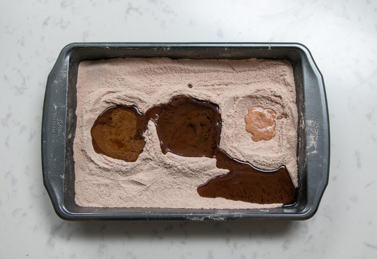Make three depressions in the dry ingredients and pour in the three wet ingredients, one in each hole. (Chung I Ho/The Epoch Times)