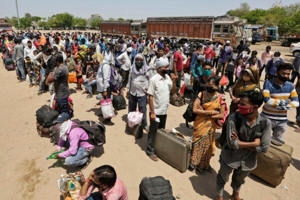 Migrant workers from other states desperate to return to their homes wait for transportation to a train station in Ahmedabad, India, on May 13, 2020. (Ajit Solanki/AP Photo)