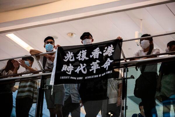 Pro-democracy demonstrators hold a flag and chant slogans during a protest calling for the city's independence at a mall in Hong Kong on May 16, 2020. (Isaac Lawrence/AFP via Getty Images)