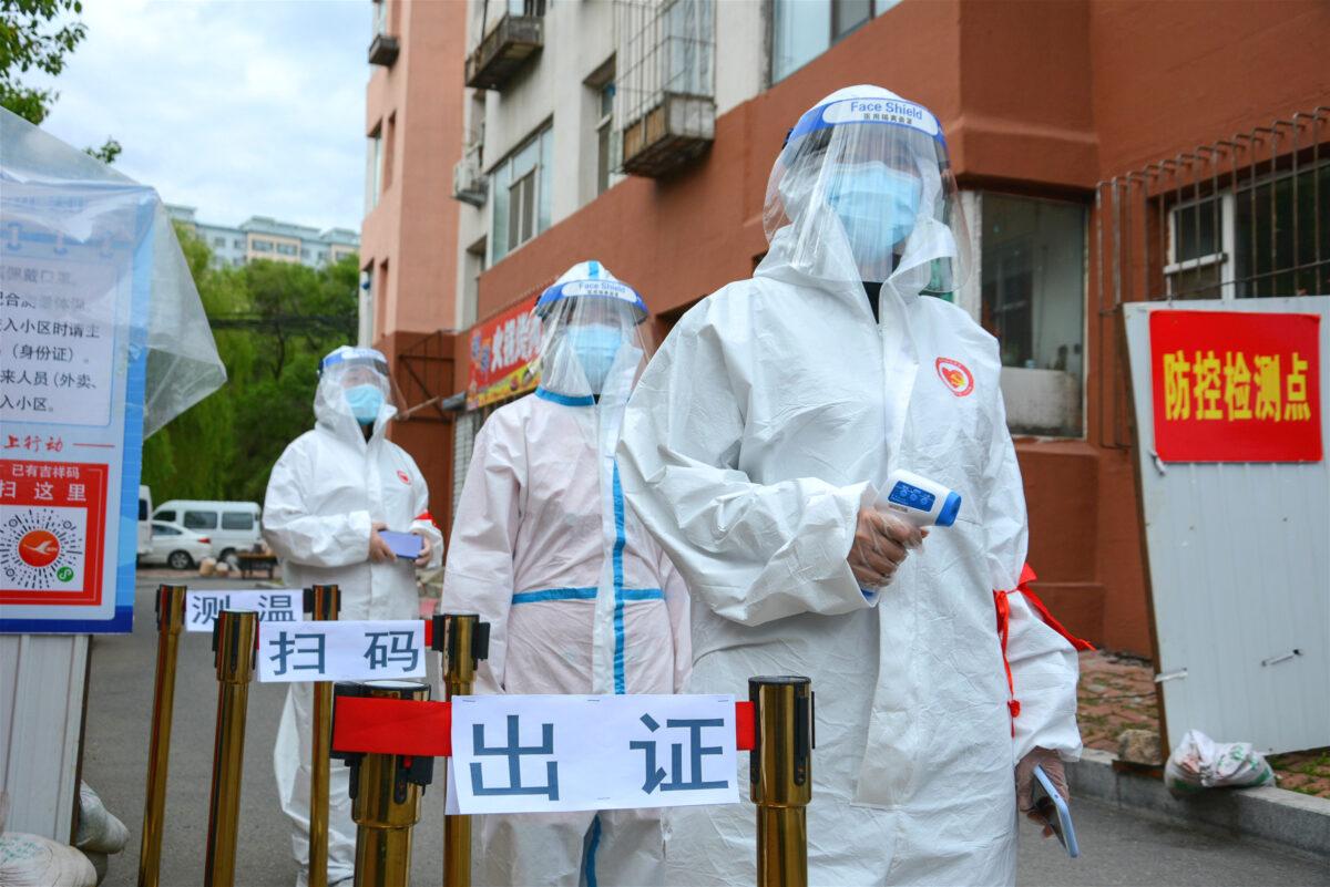 Volunteers wearing protective clothing, amid concerns of the CCP virus, at a check point outside a residential area in Jilin in China's northeastern Jilin province on May 25, 2020. (STR/AFP via Getty Images)