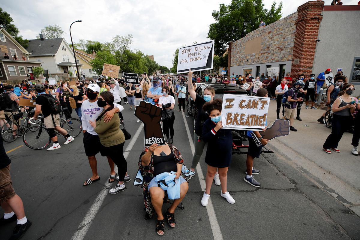 Protesters gather at the scene where George Floyd, an unarmed black man, was pinned down by a police officer kneeling on his neck before later dying in a hospital in Minneapolis, Minn., on May 26, 2020. (Eric Miller/Reuters)