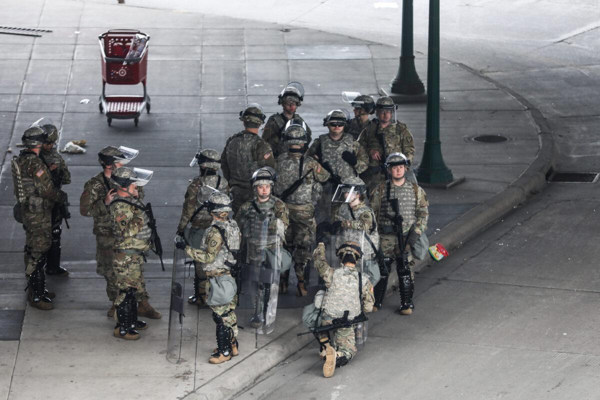 The National Guard sets up near the Lake Street/Midtown metro station as buildings continue to burn in the aftermath of a night of protests and violence following the death of George Floyd, in Minneapolis, Minn., on May 29, 2020. (Charlotte Cuthbertson/The Epoch Times)