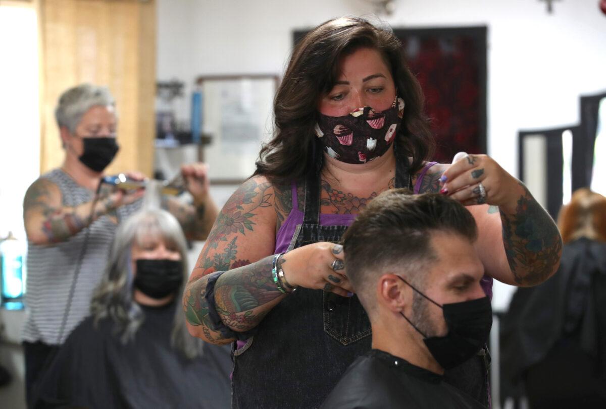 A hairstylist cuts a customer’s hair at The Parlor in Napa, Calif., on May 27, 2020. (Justin Sullivan/Getty Images)