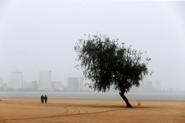 Police officers patrol a deserted beach before Cyclone Nisarga makes landfall in Mumbai, India, on June 3, 2020. (Rajanish Kakade/AP Photo)