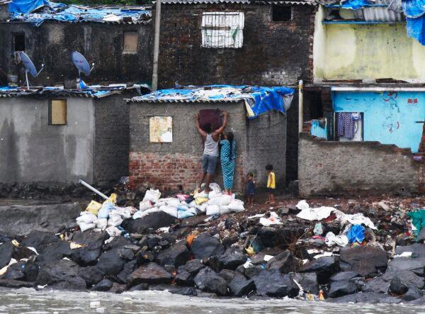 A fisherman's family seals up their window before cyclone Nisarga makes landfall in Mumbai, India, on June 3, 2020. (Rajanish Kakade/AP Photo)