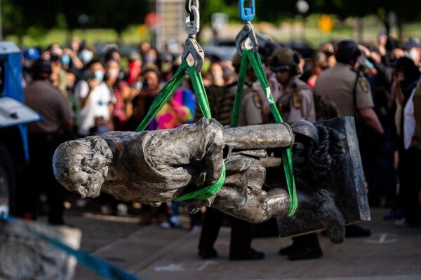 A statue of Christopher Columbus is lifted onto the back of a truck as people sing and celebrate at the Minnesota state Capitol in St. Paul, Minn., on June 10, 2020. (Evan Frost/Minnesota Public Radio/AP)