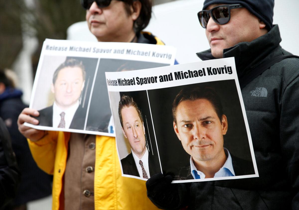 People hold signs calling for China to release Canadian detainees Michael Spavor and Michael Kovrig during an extradition hearing for Huawei Technologies Chief Financial Officer Meng Wanzhou at the B.C. Supreme Court in Vancouver, Canada, on March 6, 2019. (Lindsey Wasson/)