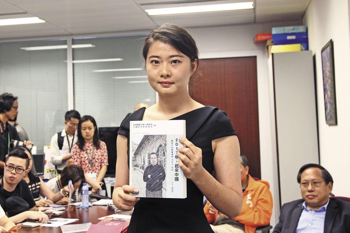 Grace Geng, Mr. Gao's daughter, holds a copy of his book, “Year 2017: Stand Up China," at the book-launch ceremony in Hong Kong on June 16, 2016. (Stone Poon/The Epoch Times)