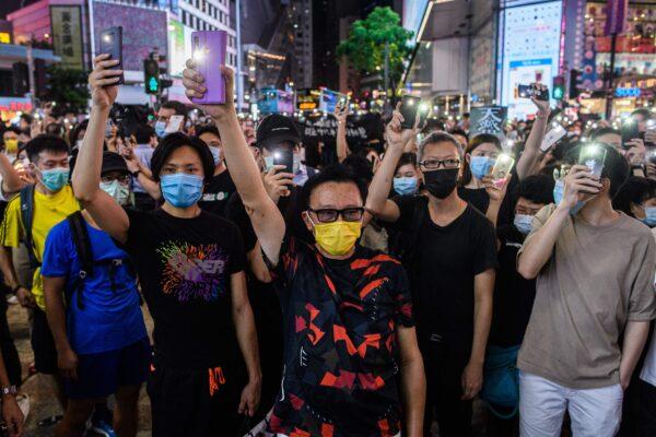 Pro-democracy activists hold up their mobile phone torches as they sing during a rally in the Causeway Bay district of Hong Kong on June 12, 2020. (Anthony Wallace/AFP via Getty Images)