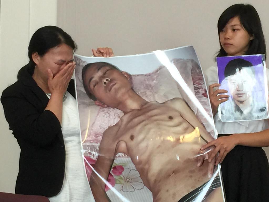 Ms. Xu (R) and her mother, Chi Lihua, hold pictures of her late father, Xu Dawei. Mr. Xu was sentenced to eight years for practicing Falun Gong. He died just 13 days after he was released. (Jennifer Zeng/The Epoch Times)