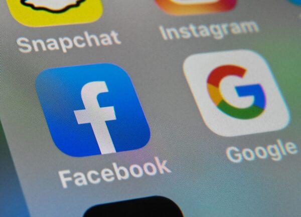 The logos of mobile apps Facebook and Google are displayed on a tablet in this file photo. (Denis Charlet/AFP via Getty Images)