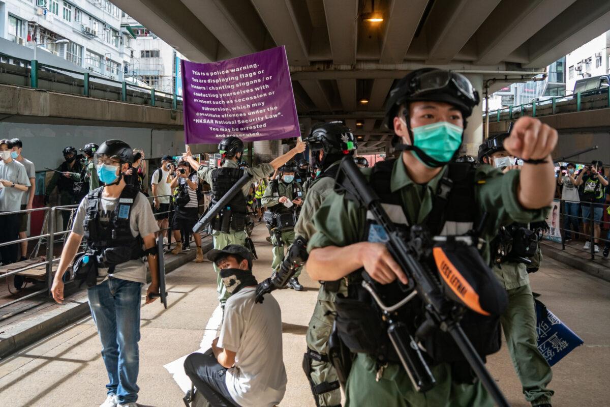 Riot police detain a man as they raise a warning flag during a demonstration against the new national security law in Hong Kong, on July 1, 2020. (Anthony Kwan/Getty Images)