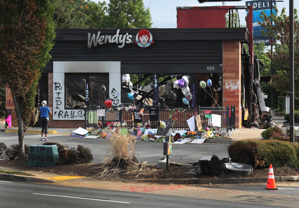 People visit the memorial setup outside the Wendy's restaurant that was set on fire by rioters after Rayshard Brooks as killed, in Atlanta, Ga., on June 17, 2020. (Joe Raedle/Getty Images)