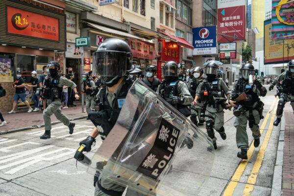 Riot police run on a street toward pedestrians during a crowd control operation at a demonstration in Hong Kong, on July 1, 2020. (Anthony Kwan/Getty Images)