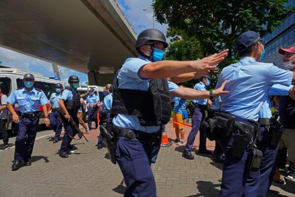 Police officers maintain orders as a 23-year-old man, Tong Ying-kit, arrives at a court in Hong Kong on July 6, 2020. (Vincent Yu/AP Photo)