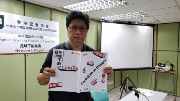 Chris Yeung, chairperson of the Hong Kong Journalists Association, holds up its annual report in a press conference in Hong Kong on July 7, 2020. (Bill Cox/The Epoch Times)