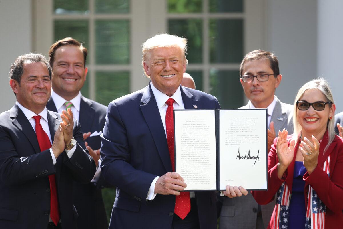 President Donald Trump holds up an executive order he signed on the White House Hispanic Prosperity Initiative in Washington on July 9, 2020. (Win McNamee/Getty Images)