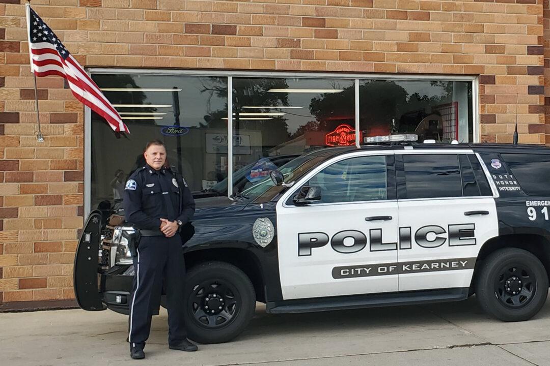 Nebraska Cop Caught on Camera Fixing Fallen American Flag Outside Auto Repair Shop