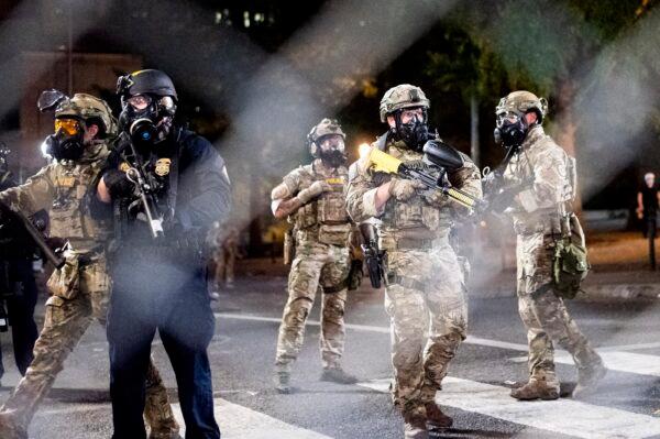 Federal agents disperse demonstrators who used fencing to block entrances and exits to the Mark O. Hatfield United States Courthouse, in Portland, Ore., on July 20, 2020. (Noah Berger/AP Photo)