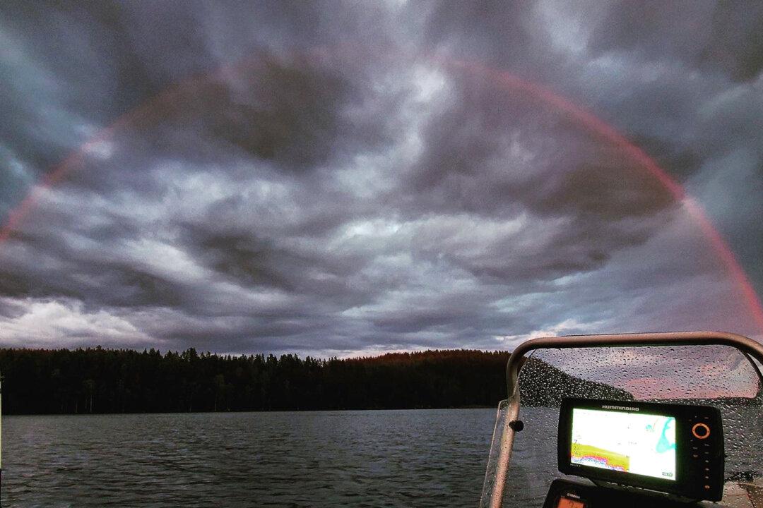 A Rare Spectacle: Fisherman Captures a Stunning Image of a Red Rainbow Over Finnish Lake