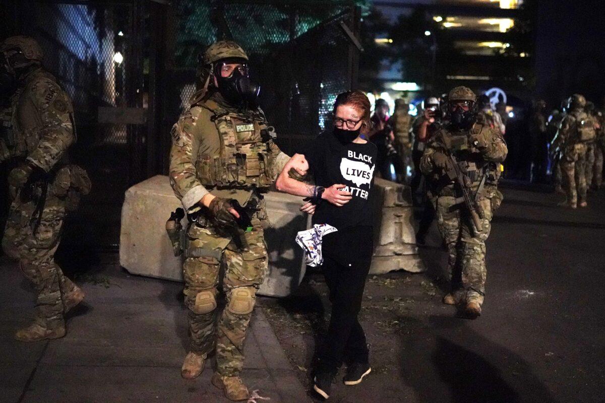 Federal officers arrest a woman wearing a "Black Lives Matter" shirt outside the Mark O. Hatfield Courthouse in Portland, Ore., in the early hours of July 30, 2020. (Nathan Howard/Getty Images)