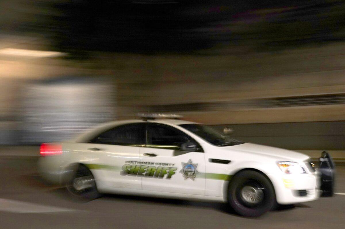 A Multnomah Count Sheriff's Office cruiser drives past the Mark O. Hatfield Courthouse during a Black Lives Matter protest in Portland, Ore., early Aug. 3, 2020. (Nathan Howard/Getty Images)