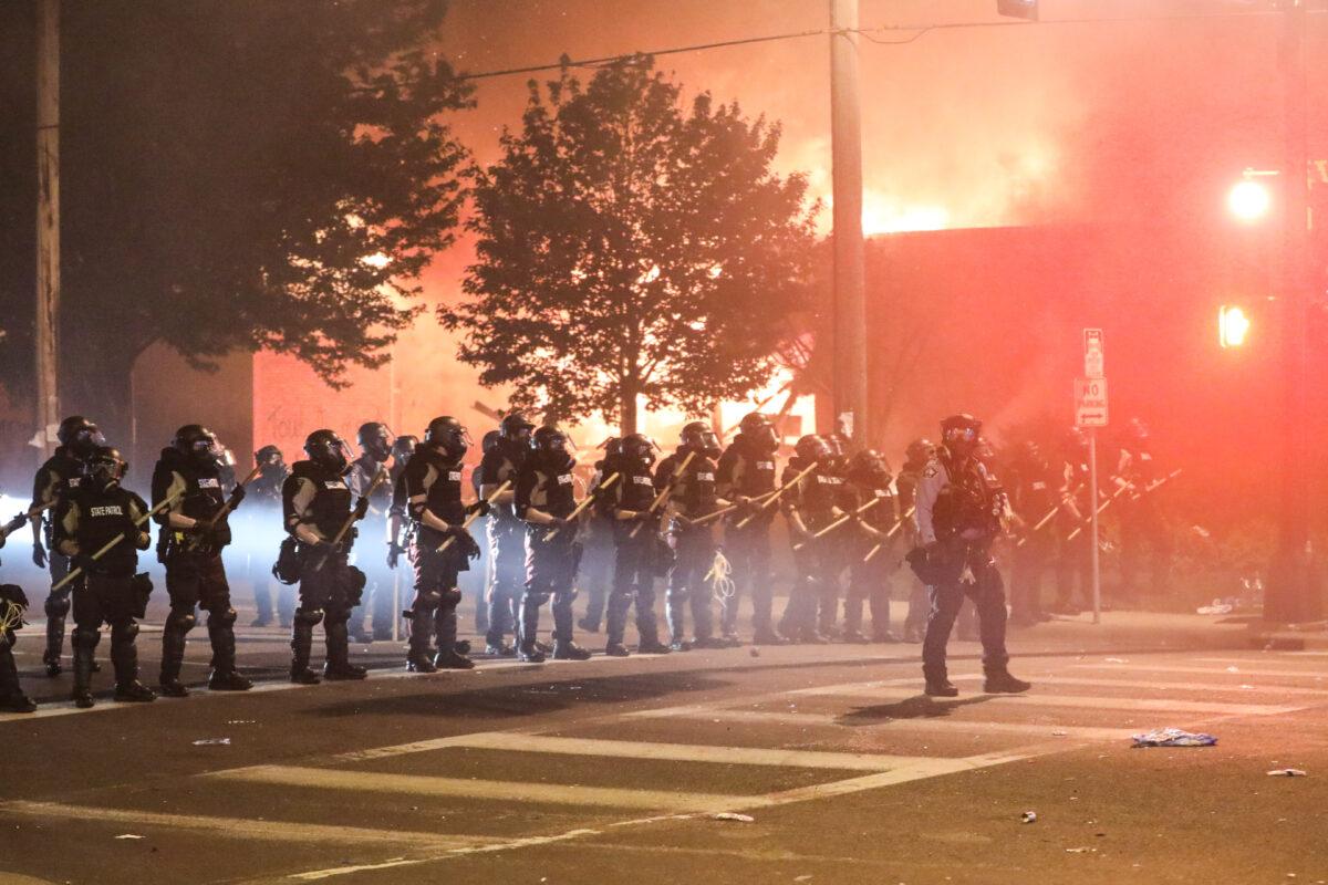 Police take back the streets at around midnight after firing copious amounts of tear gas to disperse protesters and rioters outside the Minneapolis Police 5th Precinct during the fourth night of protests and violence following the death of George Floyd, in Minneapolis, Minn., on May 29, 2020. (Charlotte Cuthbertson/The Epoch Times)