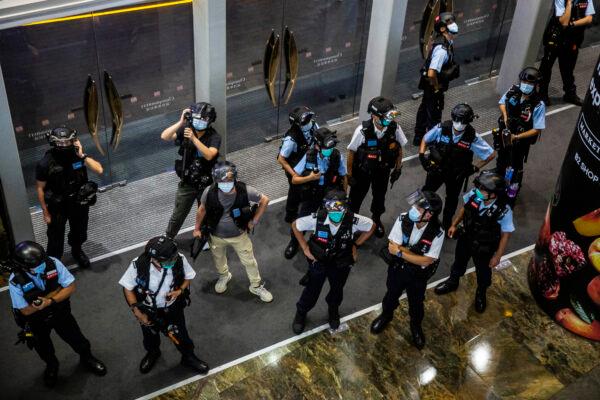 Police stand guard at a mall after people were protesting for press freedom in Kong on Aug. 11, 2020. (Isaac Lawrence/AFP via Getty Images)