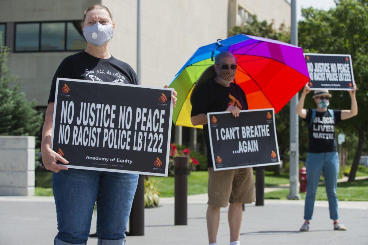 A woman holds a sign during a rally in Lincoln, Neb., on Aug. 2, 2020. (Lincoln Journal Star)