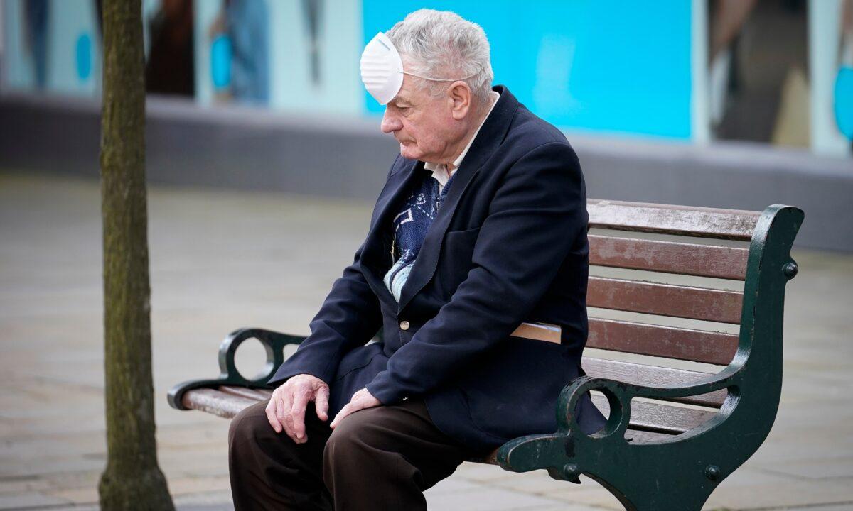A man wearing a mask resting on a bench during the COVID-19 pandemic, in Oldham, England, on July 29, 2020. (Christopher Furlong/Getty Images)