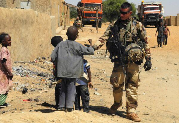 A soldier of France's Barkhane mission stands next to children as he patrols in I-n-Tillit in Mali on Nov. 1, 2017. (Daphne Benoit/AFP via Getty Images)