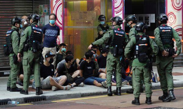 People, sitting on the ground, are arrested by police officers at a downtown street in Hong Kong, on Sept. 6, 2020. (Vincent Yu/AP Photo)