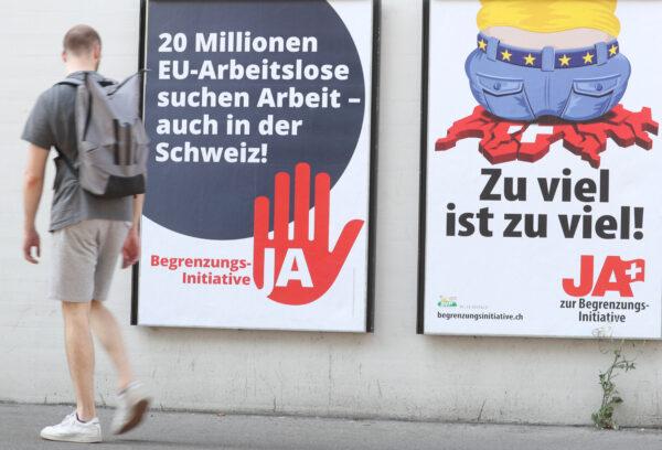 A man walks past posters of the Swiss People's Party (SVP) and of the Komitee Arbeitsplaetze fuer Einheimische schuetzen (committee to protect jobs for locals) in Zurich, Switzerland, on Sept. 17, 2020. (Arnd Wiegmann/Reuters)