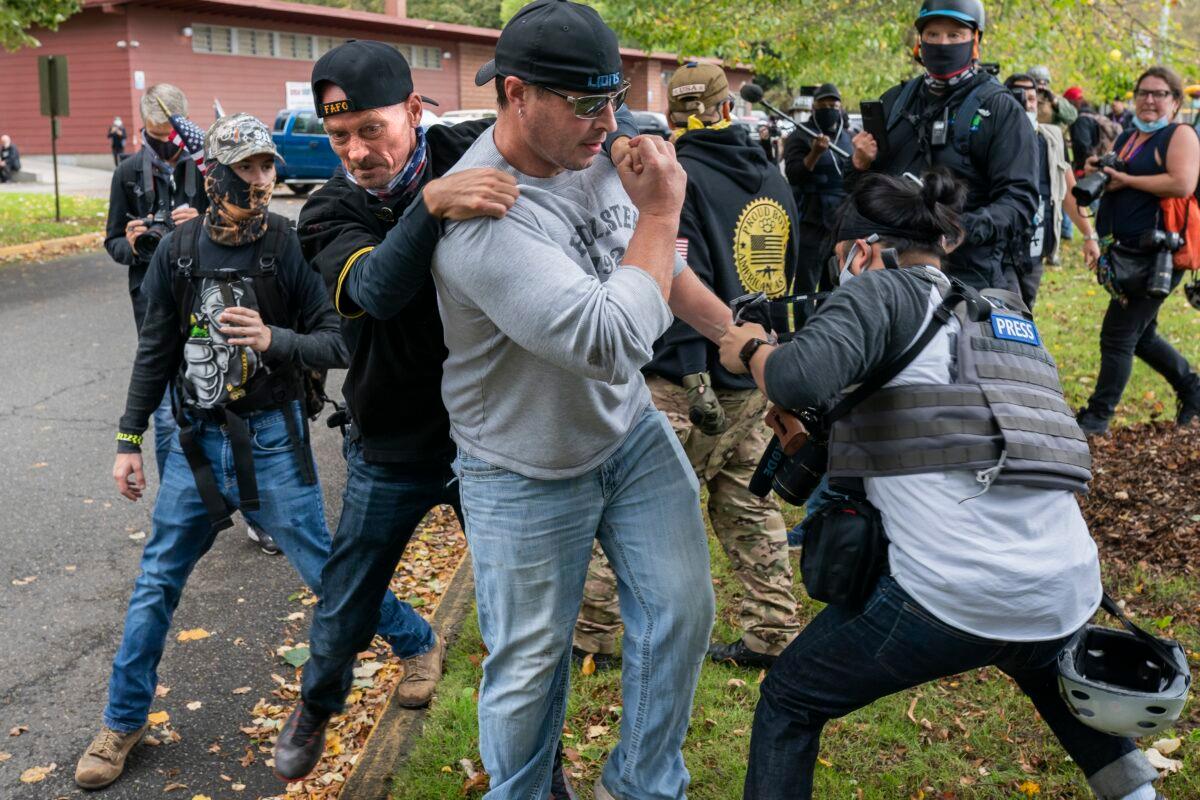 A member of the Proud Boys tackles a fellow member after he assaulted freelance journalist Justin Katigbak, right, during a rally in Portland, Ore., Sept. 26, 2020. (Nathan Howard/Getty Images)