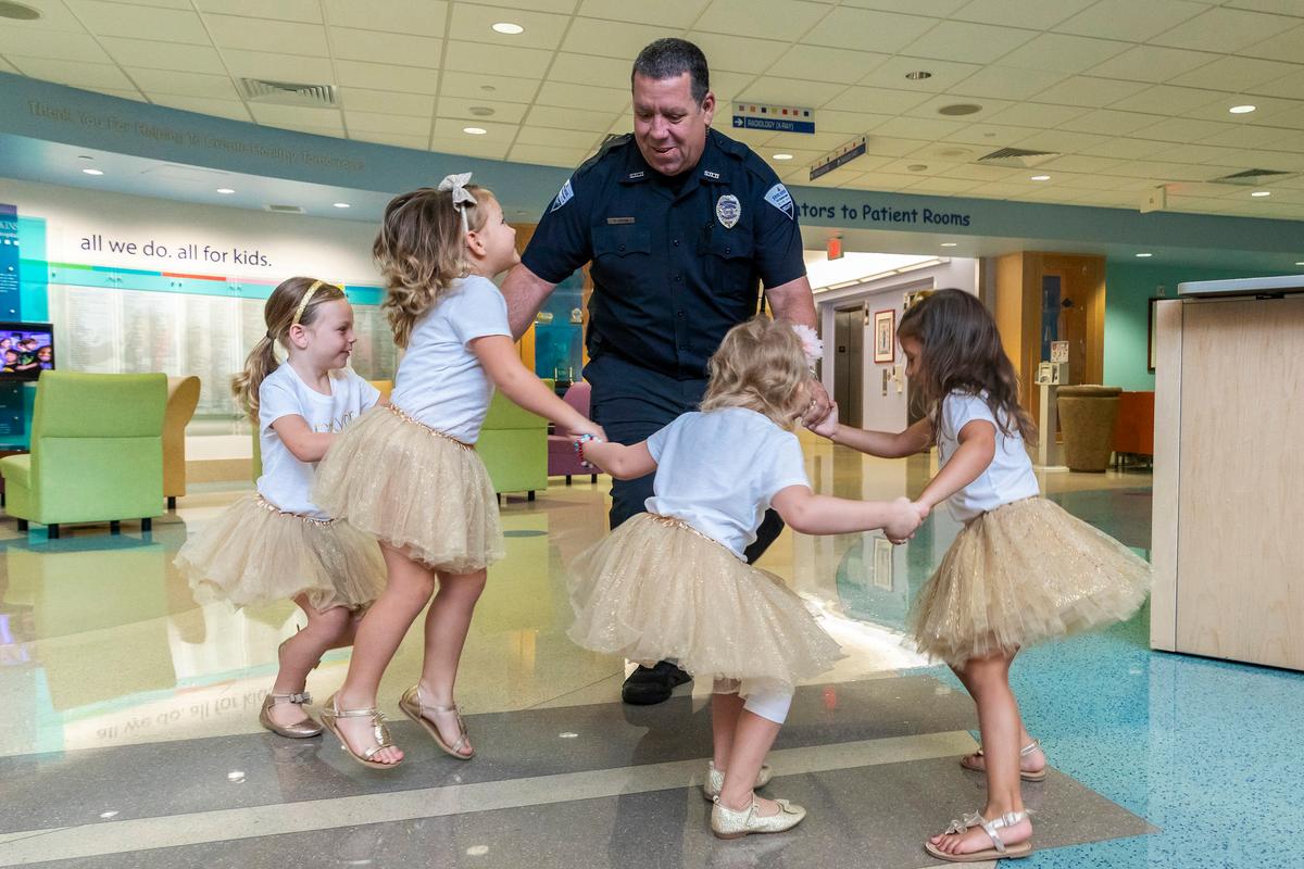 Security guard David Dean of Johns Hopkins All Children’s Hospital dances with McKinley Moore, Avalynn Luciano, Lauren Glynn, and Chloe Grimes at the hospital in St. Petersburg, Fla., Aug. 9, 2018. (Allyn DiVito/John Hopkins All Children's Hospital via AP)
