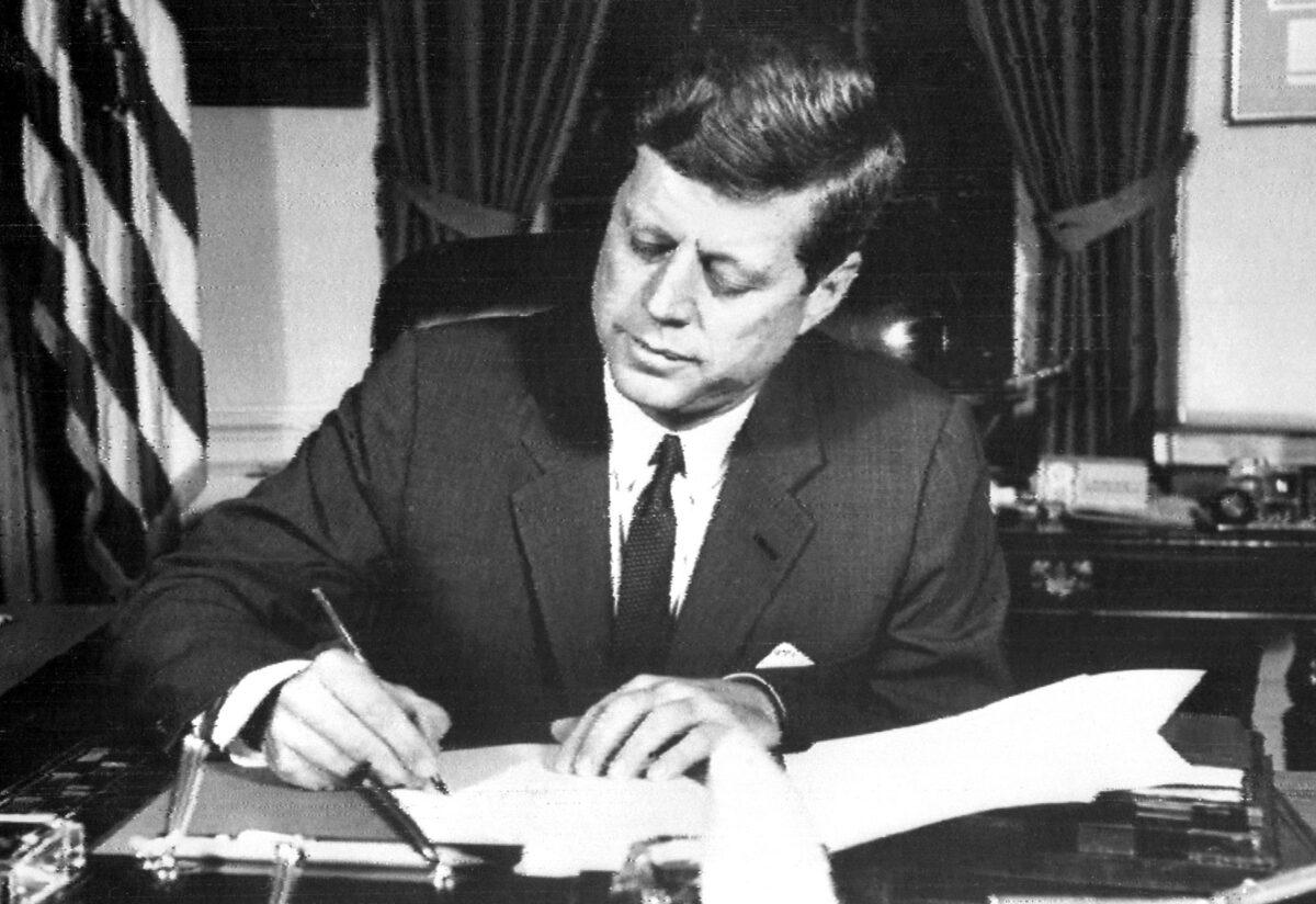 U.S. President John F. Kennedy signs the order for a naval blockade of Cuba on Oct. 24, 1962, during the Cuban Missile Crisis. (AFP via Getty Images)