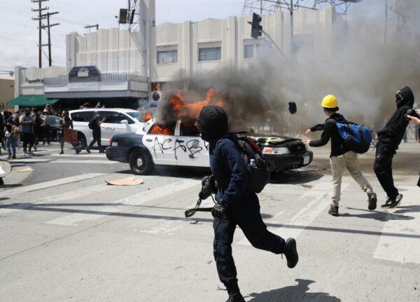 An LAPD vehicle is set on fire by rioters in Los Angeles, Calif., on May 30, 2020. (Mario Tama/Getty Images)