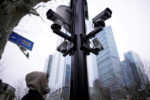 A man wearing a protective mask walks under surveillance cameras as China is hit by an outbreak of the novel coronavirus in Shanghai, China, on March 4, 2020. (Aly Song/Reuters)