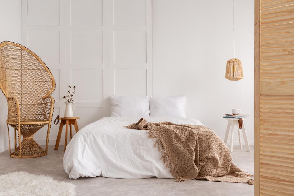 A curvaceous wicker peacock chair accents a bedroom. (Photographee.eu/Shutterstock)