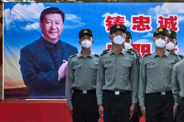 Soldiers of the People's Liberation Army's Honor Guard Battalion stand at attention in front of a photo of Chinese leader Xi Jinping at their barracks outside the Forbidden City, near Tiananmen Square, in Beijing on May 20, 2020. (Kevin Frayer/Getty Images)