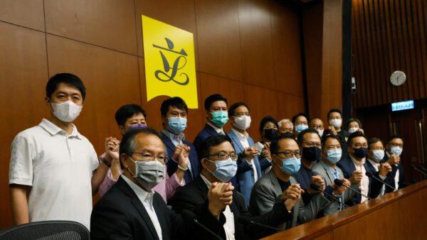 Pan-democratic legislators including Alvin Yeung, Dennis Kwok and Wu Chi-wai join their hands during a news conference as they threaten with mass resignations amid reports on Beijing plans to disqualify four opposition lawmakers, in Hong Kong, China, on Nov. 9, 2020. (Tyrone Siu/Reuters)