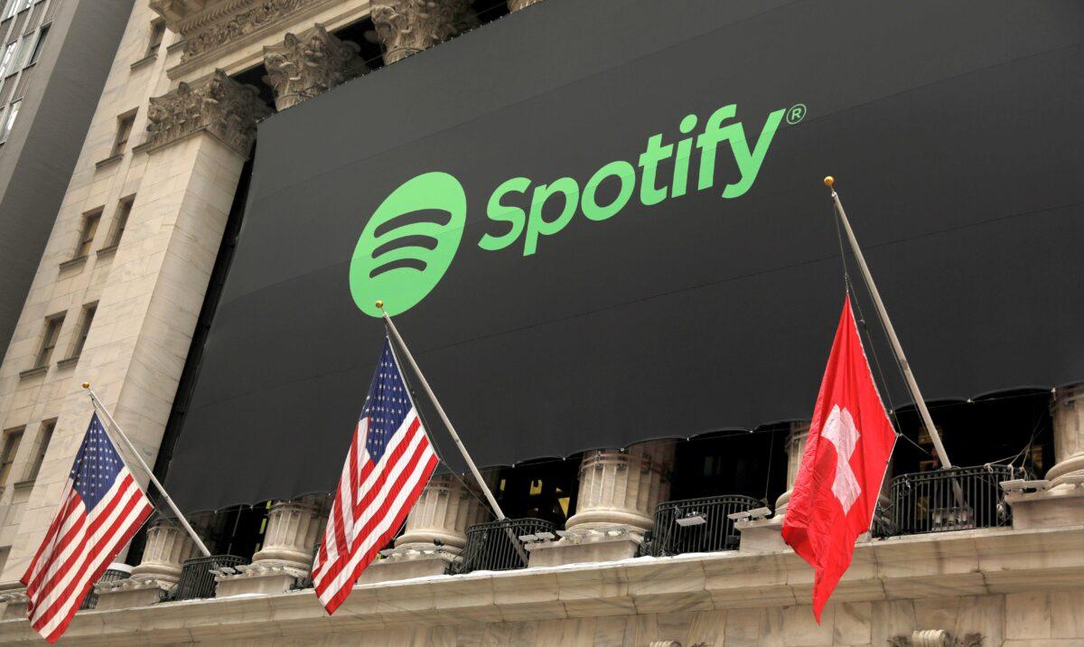 The Spotify logo hangs on the facade of the New York Stock Exchange with U.S. and a Swiss flag in New York on April 3, 2018. (Lucas Jackson/Reuters)